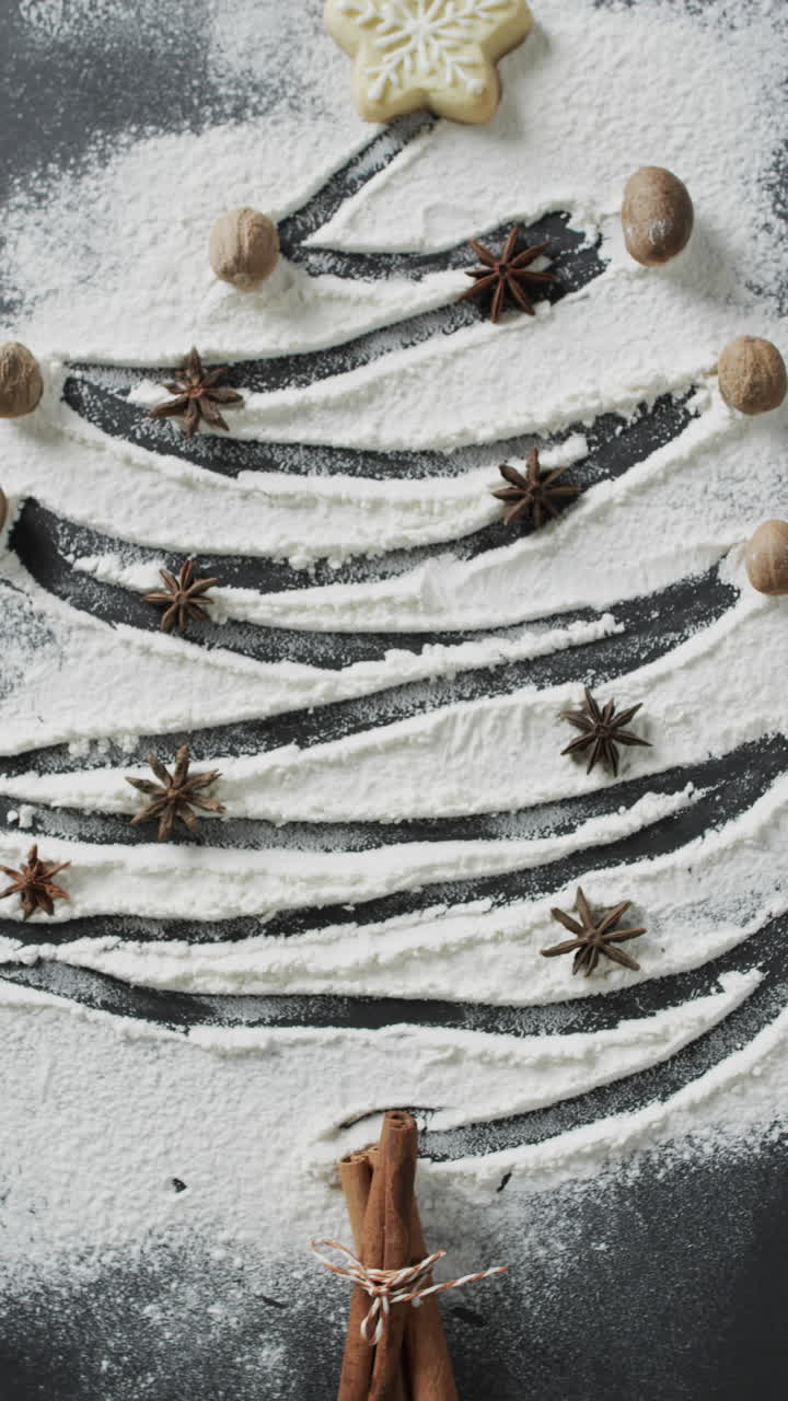 Vertical video of christmas tres with spieces drawn in sugar, and copy space on black background