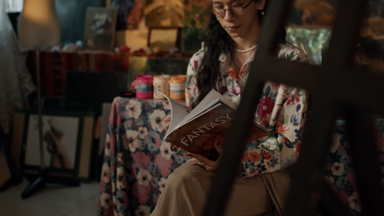 An artist ponders creativity in a cozy studio space, deep in thought