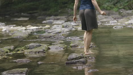 woman walking through a shallow river