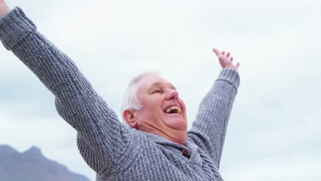 happy senior woman standing on the beach