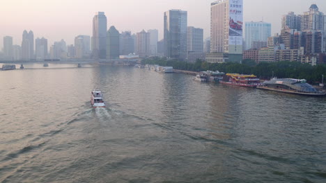 guangzhou pearl river tour boat sailing along the river with living apartment and office buildings on the river sides in the afternoon