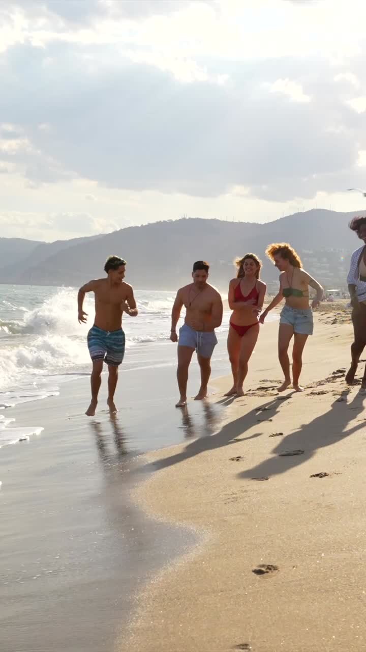 Group of friends running on the beach