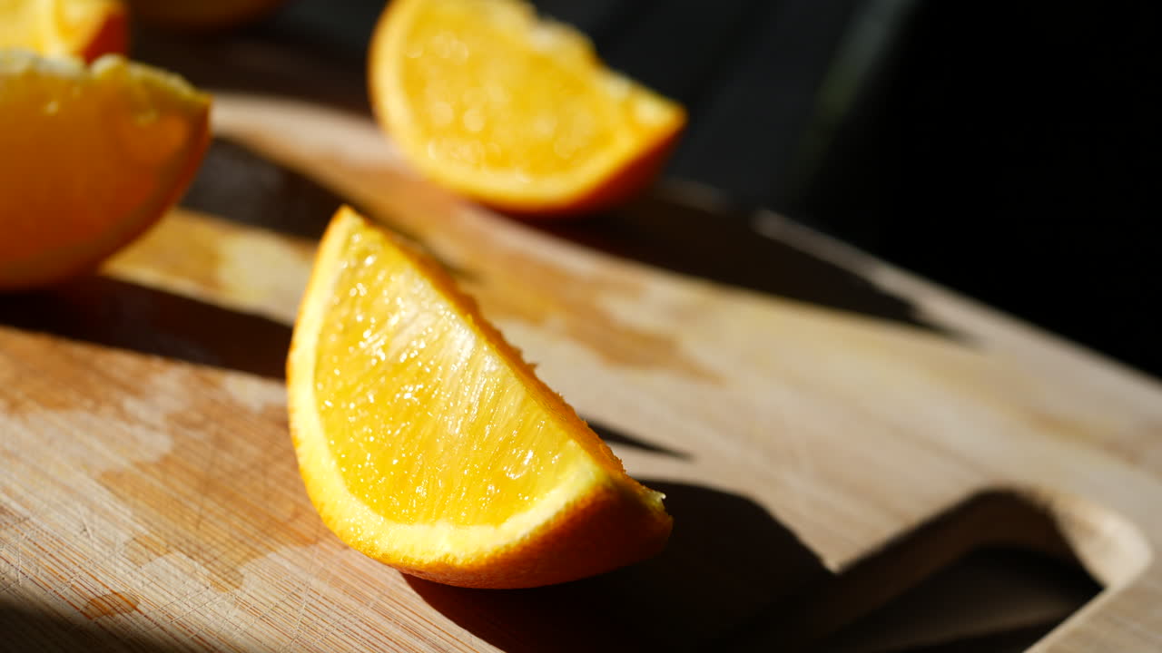rodajas de fruta naranja en una tabla de cortar a la luz del sol para un refrigerio saludable