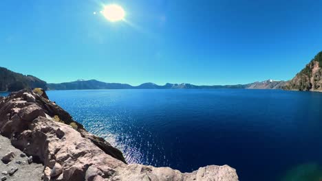 Pan-over-the-edge-of-the-lake-at-Crater-Lake-National-Park-in-Oregon-on-a-blue-sky-day