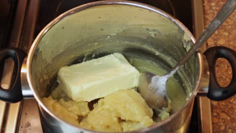 adding sticks of butter to a saucepan for a boiled icing