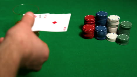jugador poniendo su mano de póquer de casa completa en la mesa