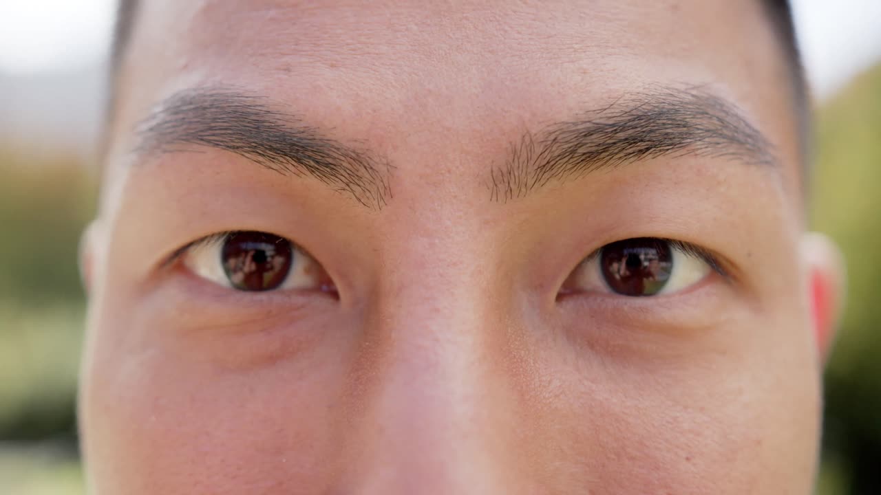 슬로우 모션으로 정원에서 카메라를 바라보고 미소 짓는 행복한 두 인종 남자의 초상화