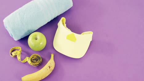 fruits, napkin, measuring tape, dumbbells and cap