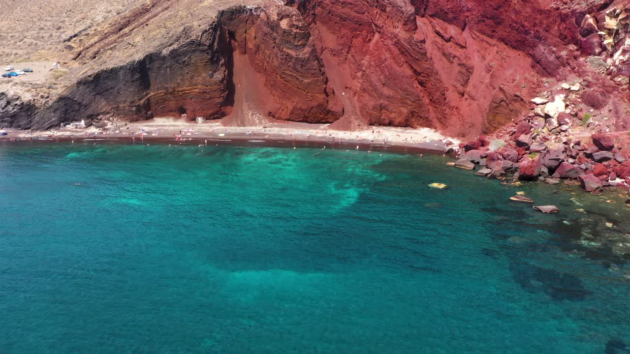 vuelo aéreo a través de la playa roja en santorini, grecia