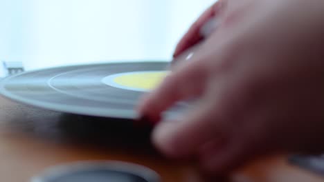 woman placing vinyl disc on old record player