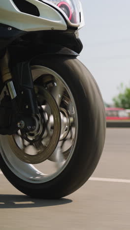 contemporary motorcycle vehicle drives fast along empty plain road on large city highway on sunny spring day slow motion close view