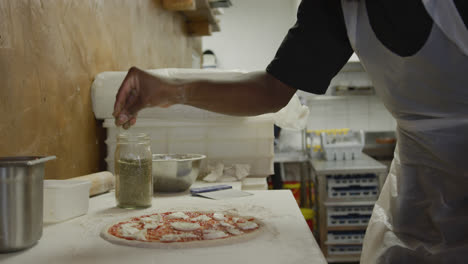 mixed race man making a pizza