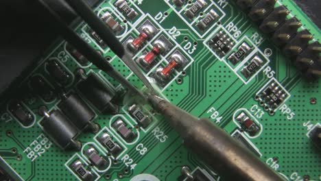 tiny electronic component precise soldering on circuit board, close up