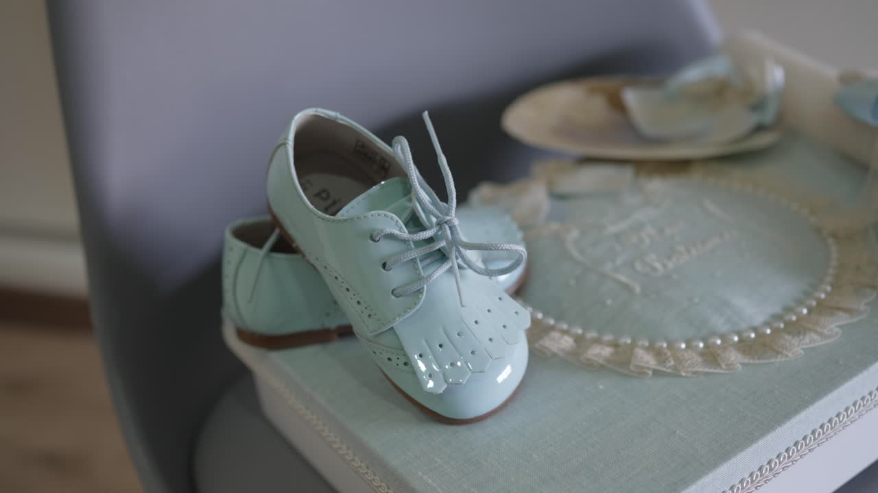 soft baby shoes in blue resting on decorated memory box with lace