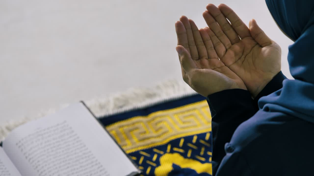 히자브를 입은 젊은 이슬람 여성은 모스크에서 하나님을 찬양하고 이슬람 신앙을 실천하고 있습니다.