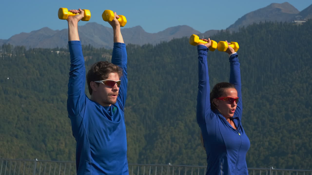 산 에서 야외 에서 웨이트 리프팅 하는 부부