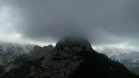 drone footage of a big mountain in fog and mist drone moving forward and filmed in 4k filmed in slovenian mountain in the alps in beautiful cloudy weather