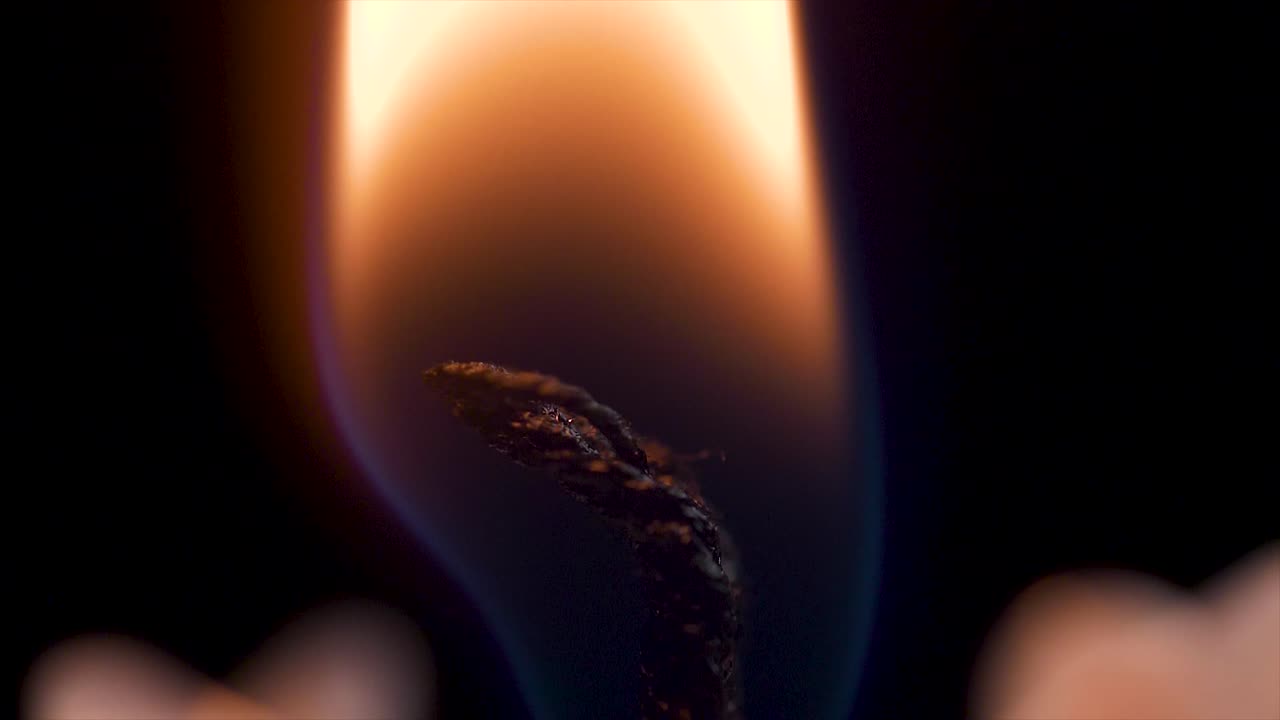 primer plano de una llama de vela y una mecha