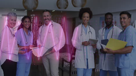 animation of heart rate monitor over team of diverse doctors and health workers smiling at hospital