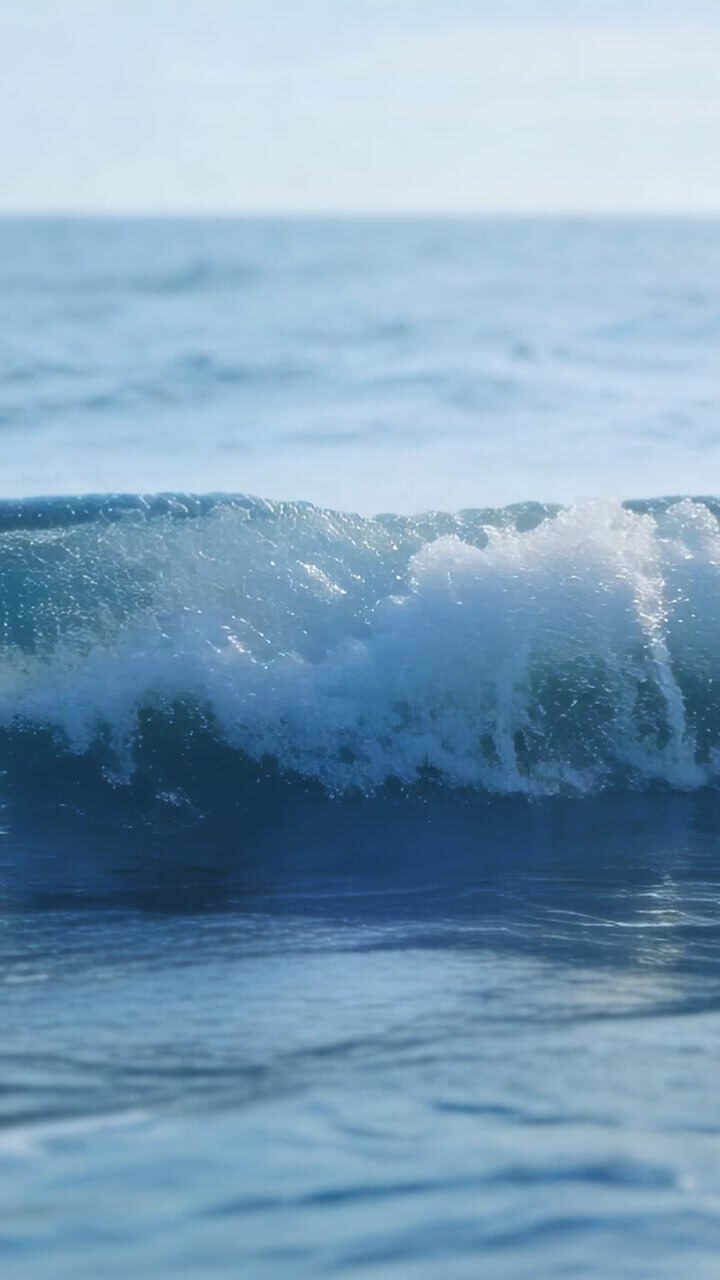 Vertical video: Swell rising wave crest curling and breaking foam moving to near lens for research