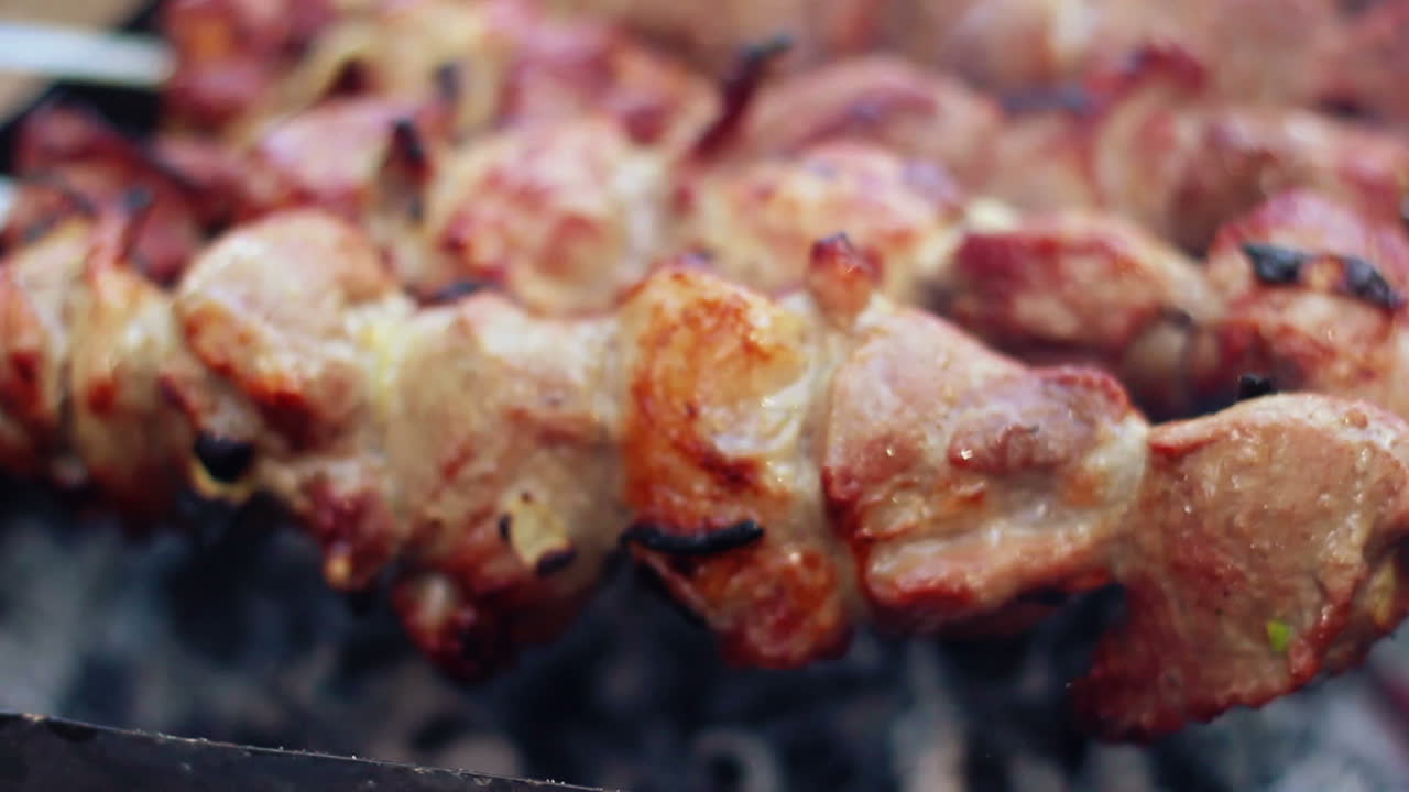 Carne BBQ alla griglia su carbonella. Cottura di spiedini di carne su spiedini metallici.