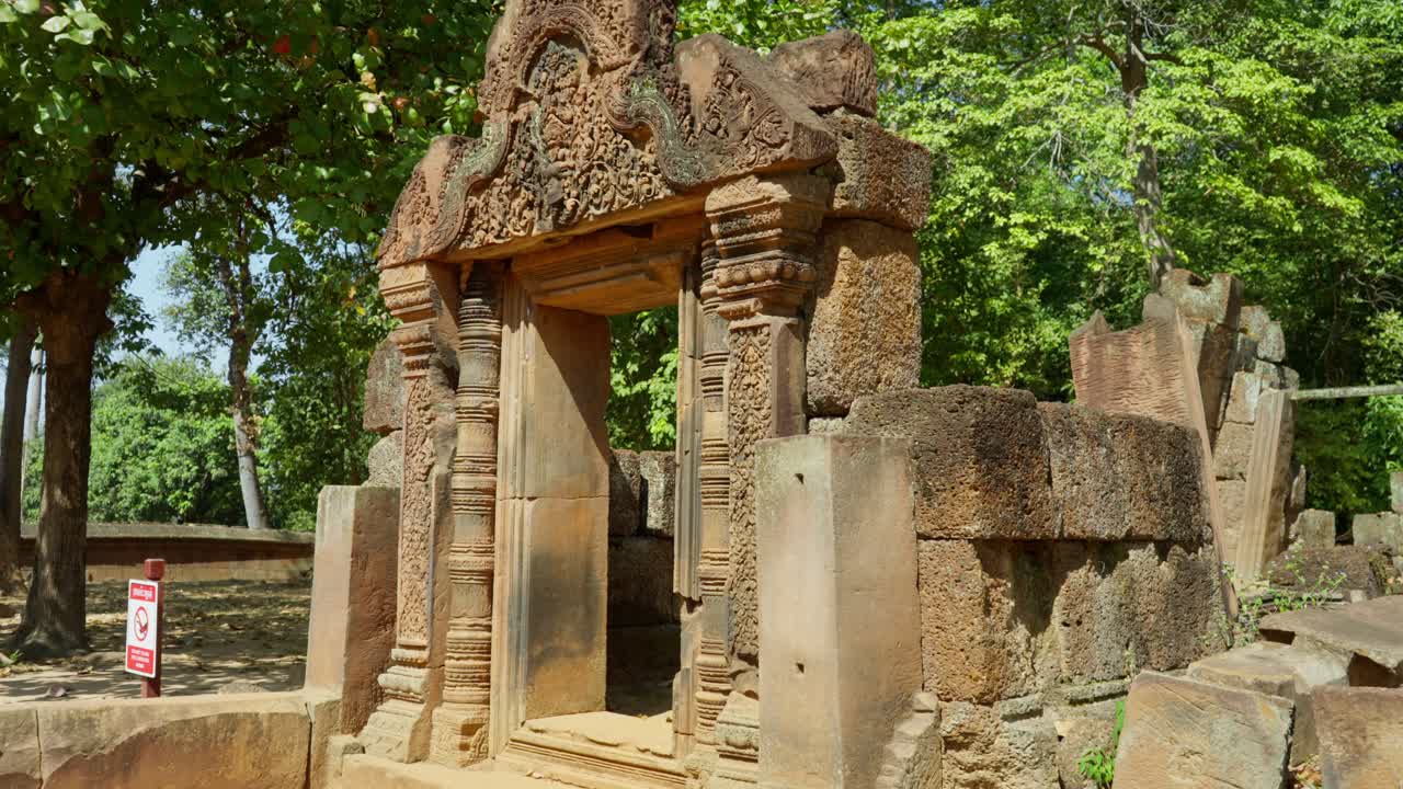 Establishing front of Banteay Srei temple arch near Angkor Watt surrounded by lush forest in Cambodia, intricate carvings
