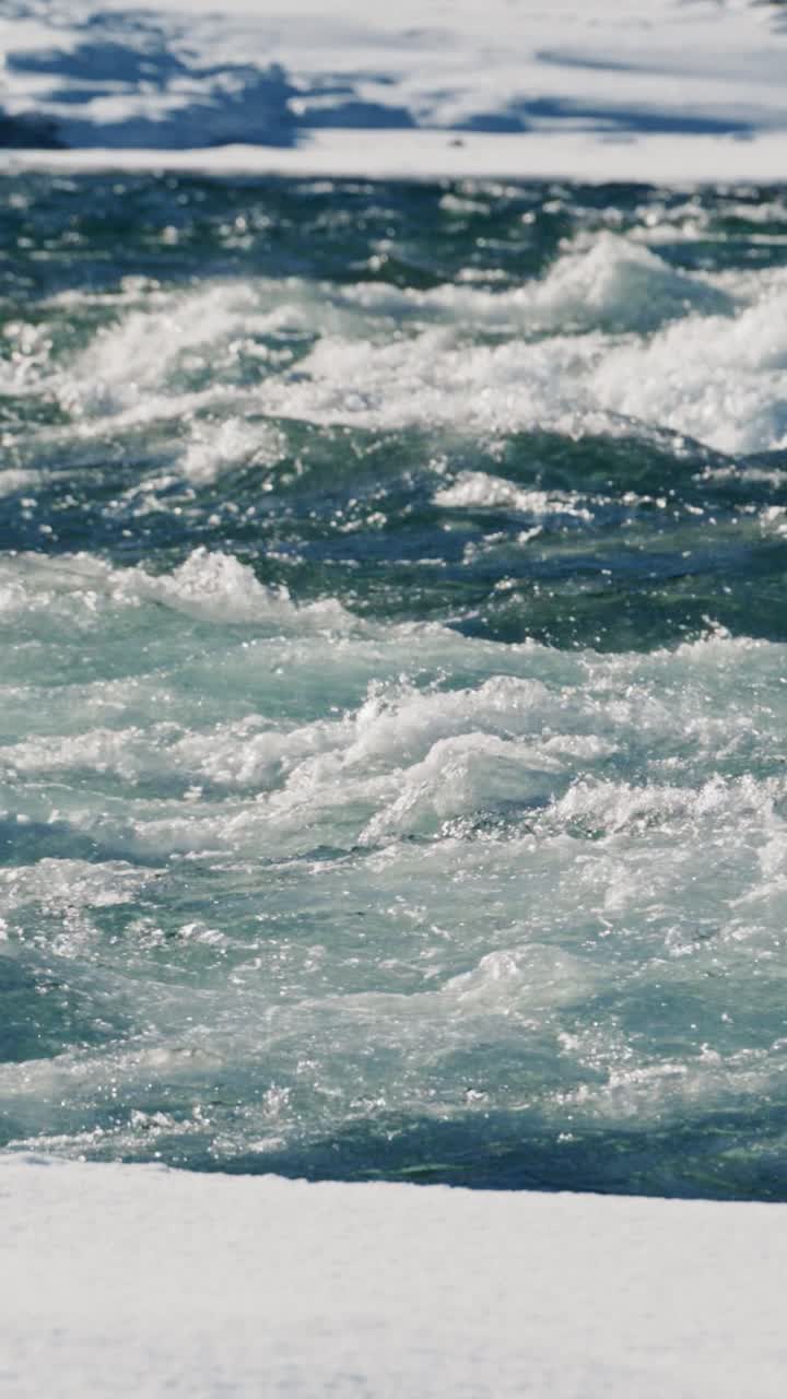 Fast-flowing river in winter with snow