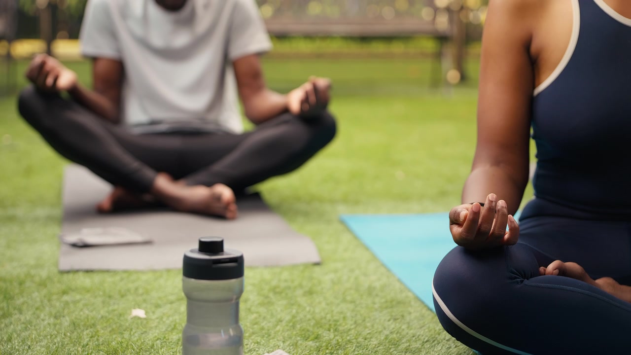 Close up of woman meditating beside yoga equipment on yoga mat