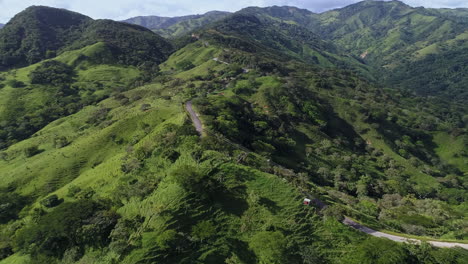 empujando una toma aérea siguiendo una ventosa carretera rural de montaña hasta una exuberante cordillera, 4k