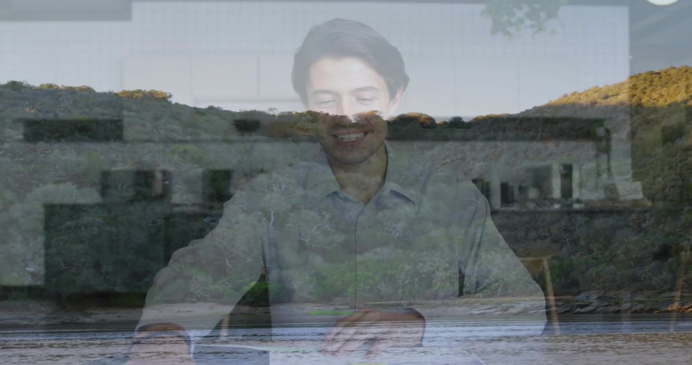 Vertical video: Recording man in light shirt reading notes and gesturing in studio, coastal overlay