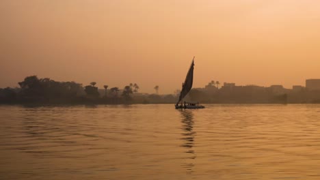 Luftaufnahme-Des-Sonnenuntergangs-Am-Nil,-Traditionelle-ägyptische-Segelboote-In-Assuan,-Ägypten,-Verkörpert-Das-Konzept-Des-Zeitlosen-Maritimen-Erbes-Und-Kulturellen-Reichtums