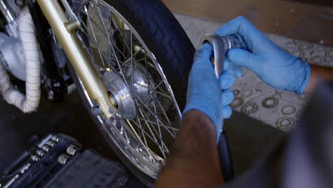 male mechanic repairing motorbike in repair garage 4k