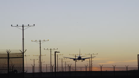 airplane landing from overhead after sunset