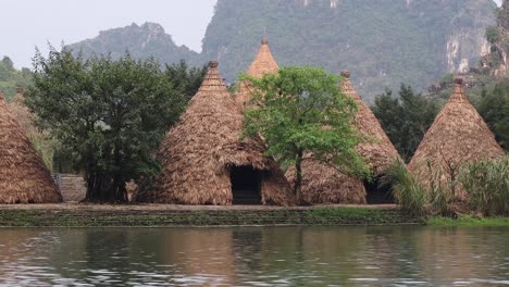 traditional huts near river and mountains