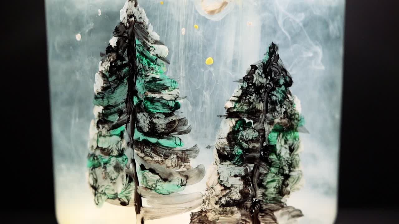 White paint floating in water tank with pine tree drawing inside. Stable shot with the Sony a7iii.