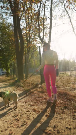 woman walking her pug in the park