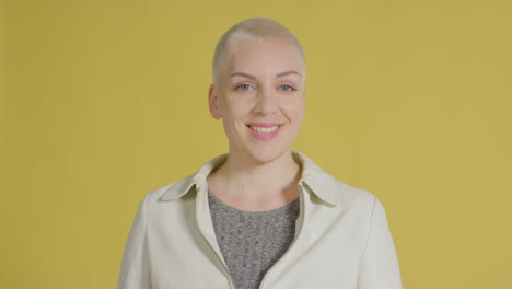 female caucasian model posing for studio portrait with yellow backdrop 02