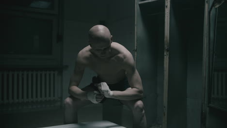 pale bald skinny man badnages his hands in the creepy old bathroom at night