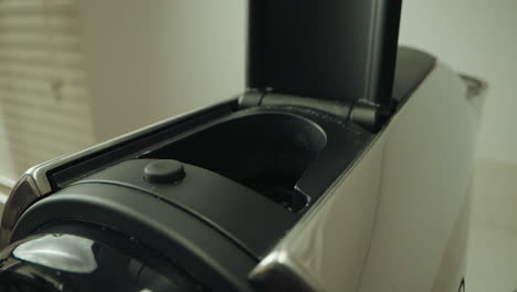 inserting capsule into a coffee machine, focusing on the action and the machine's mechanism