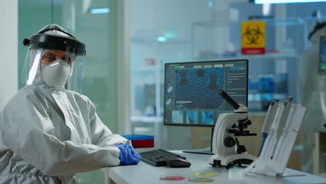 portrait of tired woman scientist in coverall looking at camera