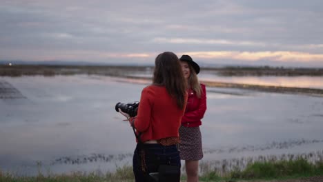 women taking photos at sunset near the river
