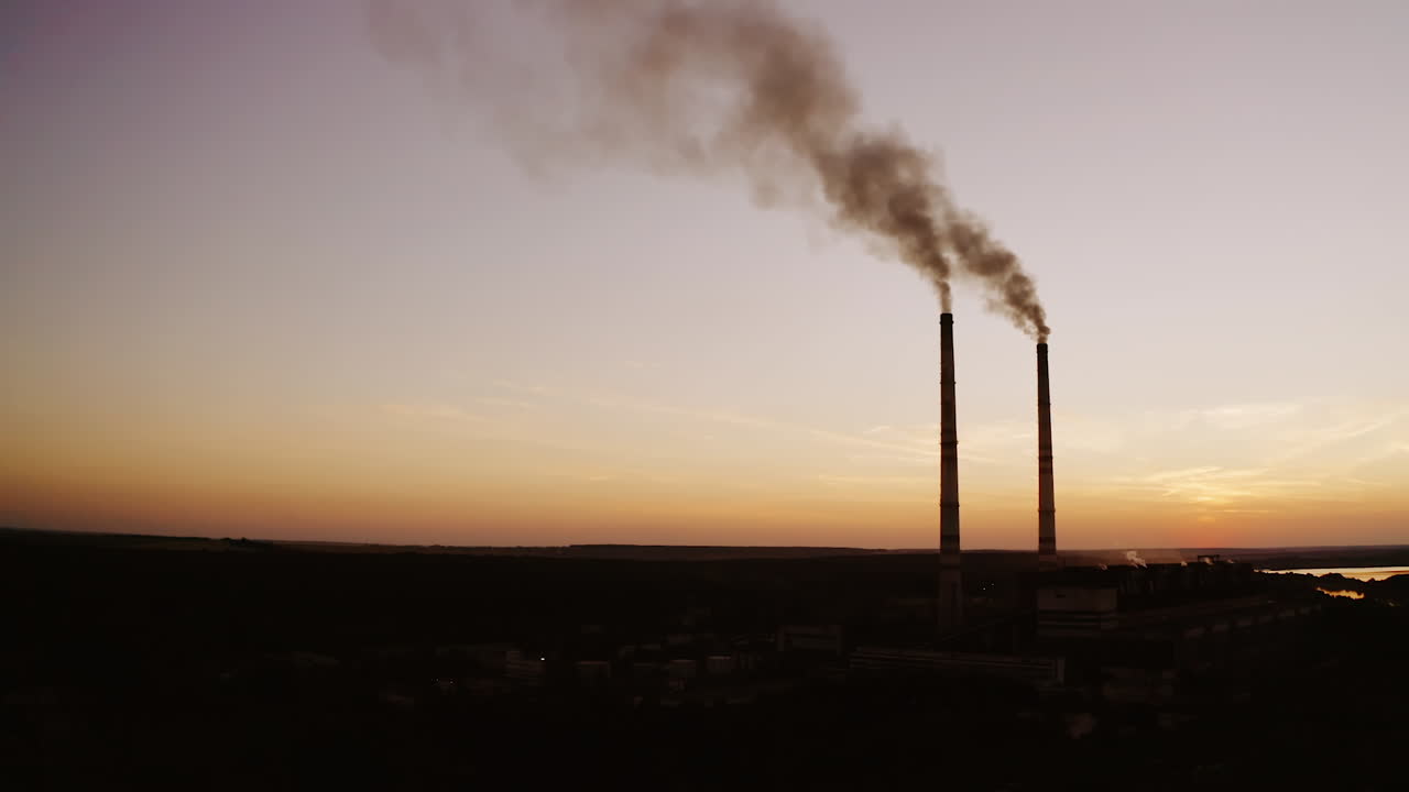 Highly polluting factory plant. Smoke from the pipes of plant at sunset