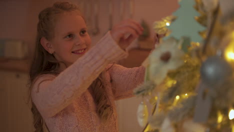 niña decora el árbol de navidad con adornos