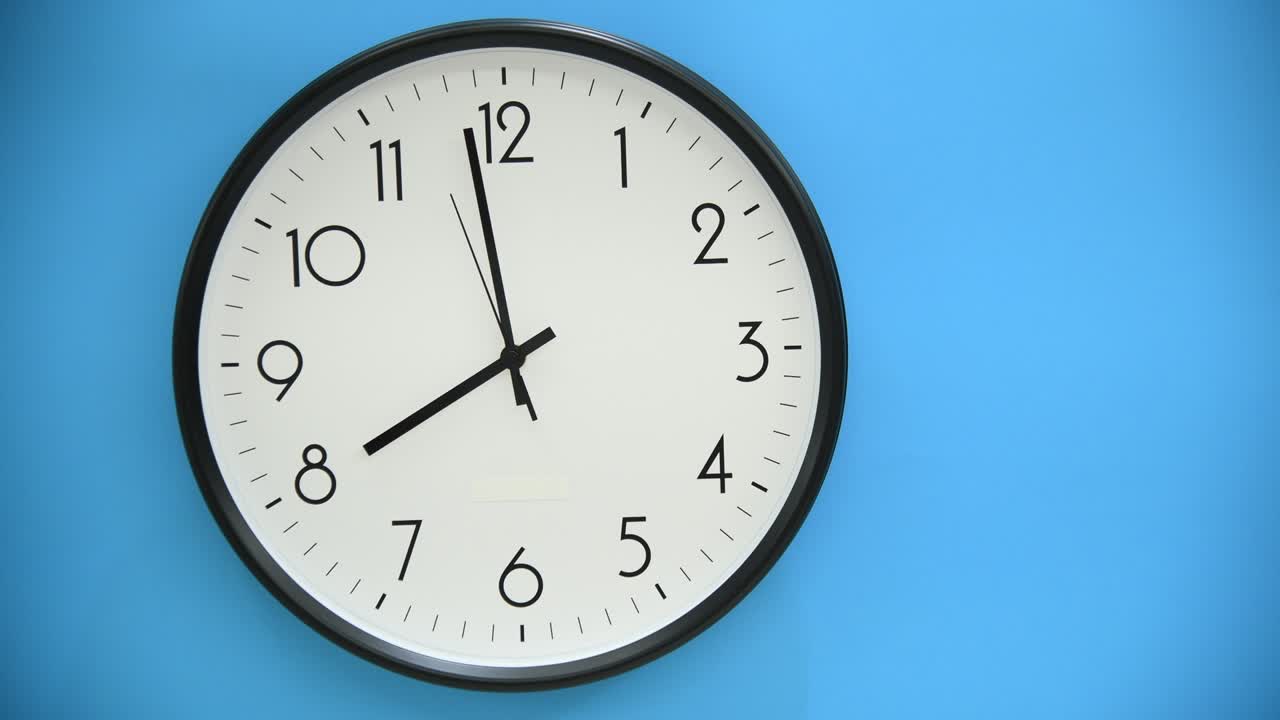 Orologio da parete bianco su sfondo blu.