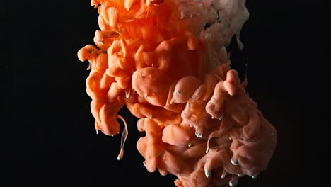 orange and white ink mixing in water