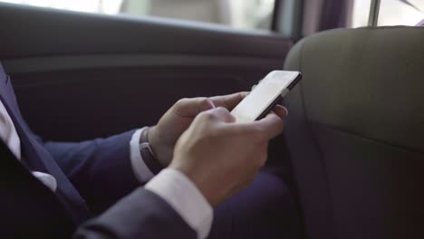 foto recortada de un hombre de negocios usando un teléfono inteligente en el coche