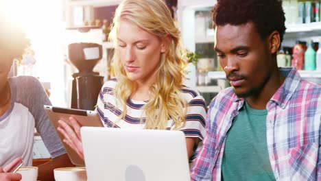 Gruppe-Von-Freunden,-Die-Mobiltelefon-Und-Laptop-Nutzen