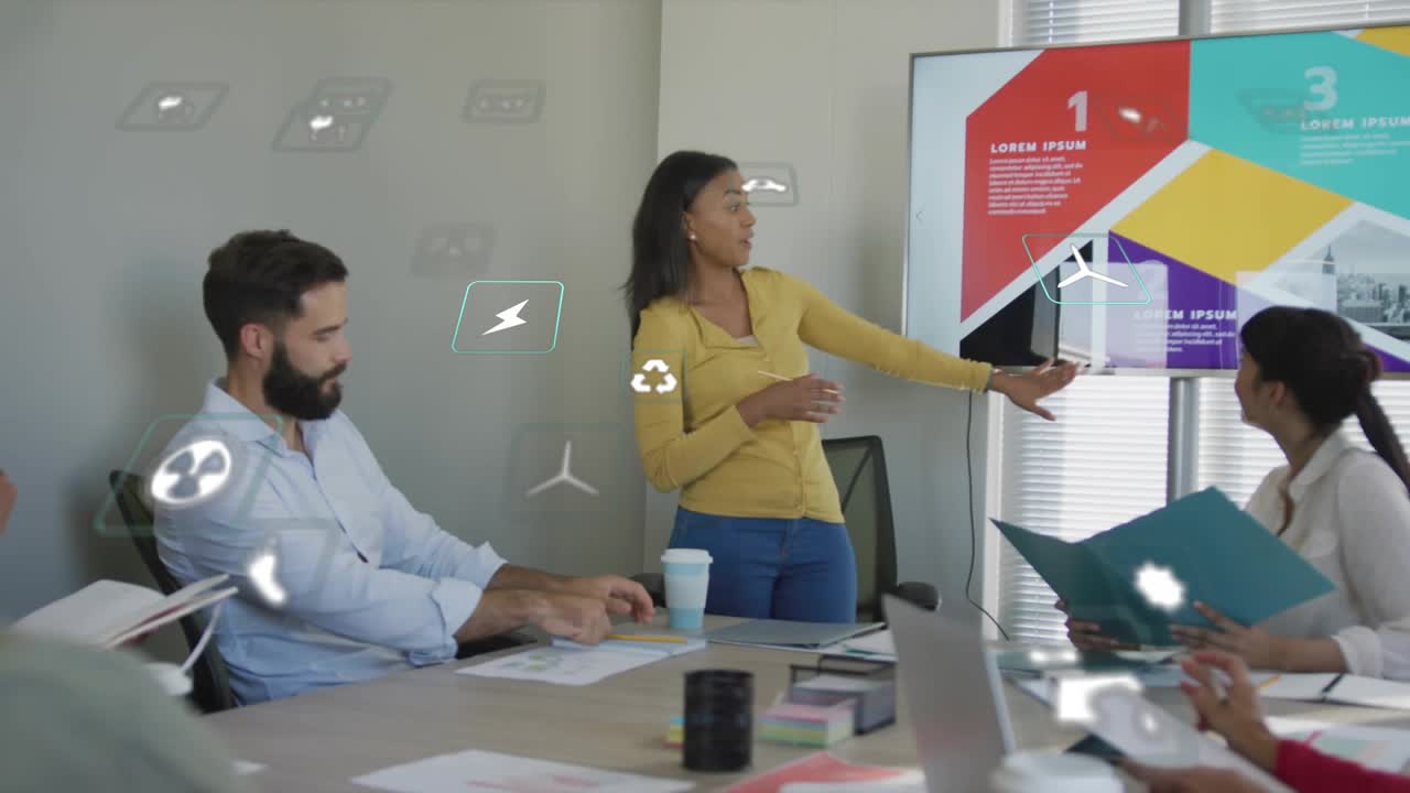 Presenter clicking remote, outlining animated chart on monitor as colleagues jot notes in boardroom