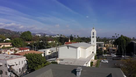 aerial shot rising over roofline to reveal church and downtown hollywood in the distance