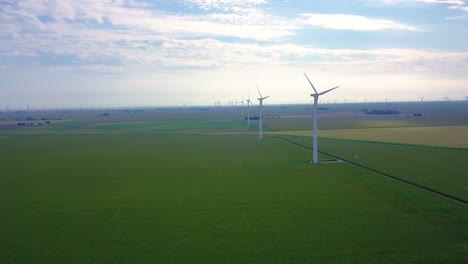 aerial view flying down a row of alternative energy wind turbines on lafayette agricultural farmland, indiana